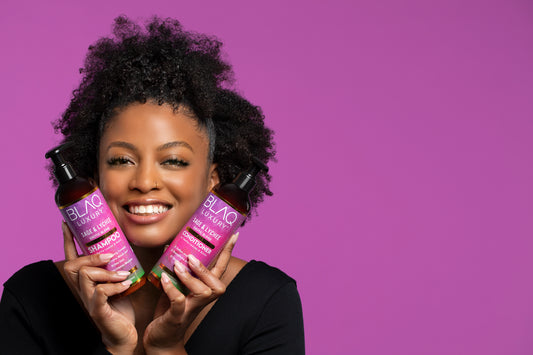 woman holding two bottles of hair care products